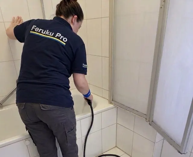 Mitarbeiterin von Feruku Pro reinigt ein Badezimmer mit dem Dampfreiniger