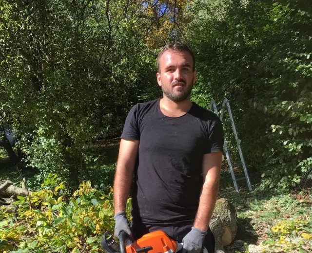 Mitarbeiter von Feruku Pro mit Motorsäge beim Baumrückschnitt